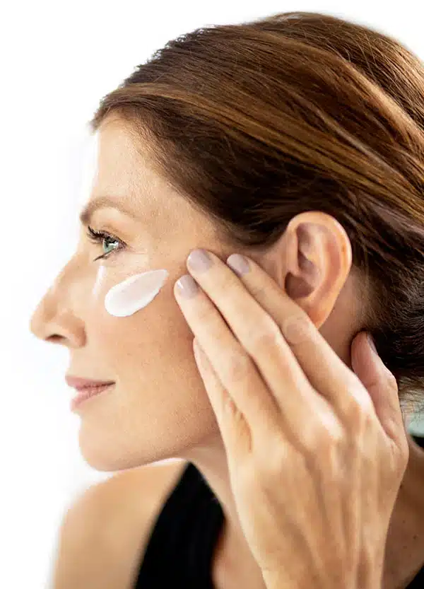 kvinne som påfører pep up produkt i ansiktet
